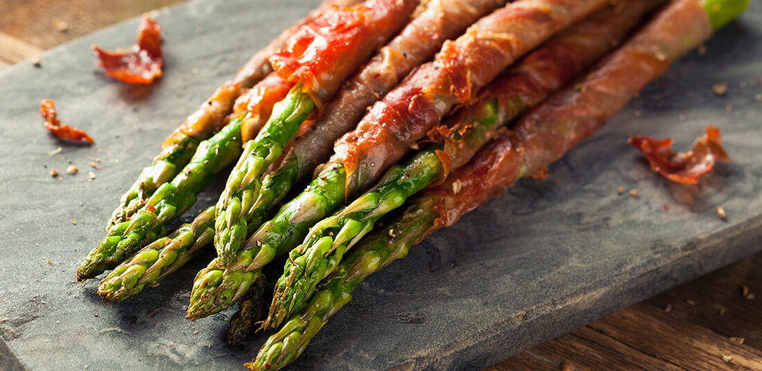 Prosciutto Wrapped Asparagus on marble cutting board